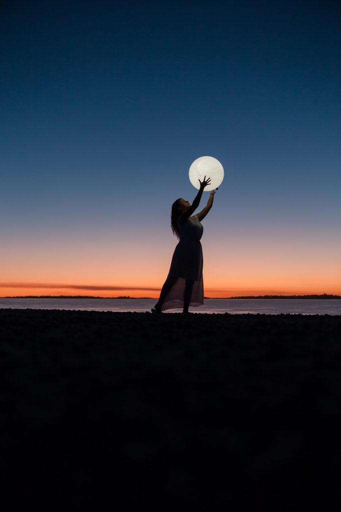 lua cheia ao fundo e silhueta feminina