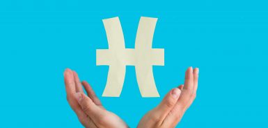 Duas mãos em volta do símbolo do signo de Peixes, com um fundo azul