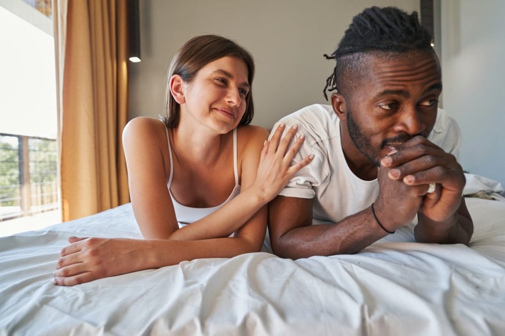 Uma jovem mulher chama a atenção do seu parceiro, que olha para o lado e parece estar com o pensamento em outro lugar, ilustrando notícia sobre atenção no amor