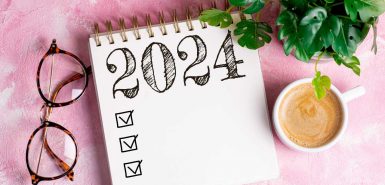 Lista de resoluções de 2024 com caderno, xícara de café na mesa, para ilustrar o Calendário Astrológico 2024