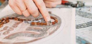 Materiais e ferramentas para confecção de mosaicos de vidro colorido, desenhando a imagem de uma mulher com o símbolo de Virgem, ilustrando artigo sobre o trânsito da Lilith em Virgem