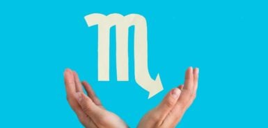 símbolo de escorpião em branco, em um fundo azul claro, com a imagem de duas mãos abaixo do símbolo