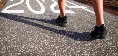 um pessoa corredora prestes a ultrapassar a escrita do número 2024, para o mapa do ano 2024