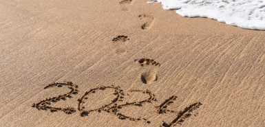 Escrita do ano "2024" na areia de uma praia, para ilustrar artigo de previsões de 2024 para cada signo