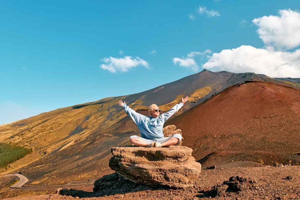 imagem de uma mulher com os braços abertos sob pedras em uma montanha, para artigo Aquário combina com qual signo