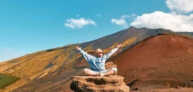 imagem de uma mulher com os braços abertos sob pedras em uma montanha, para artigo Aquário combina com qual signo
