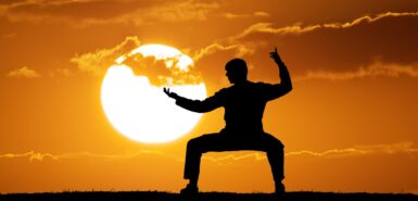 Homem na contraluz fazendo uma postura de guerreiro, para ilustrar artigo sobre o significado de marte no mapa astral