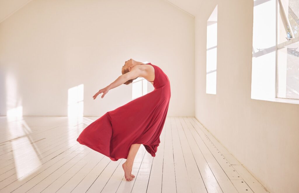 Liberdade, energia e treinamento de balé ou dançarina de salão em estúdio de dança, alongada e com um vestido vermelho fogo, para notícia que explica que vênus está em áries