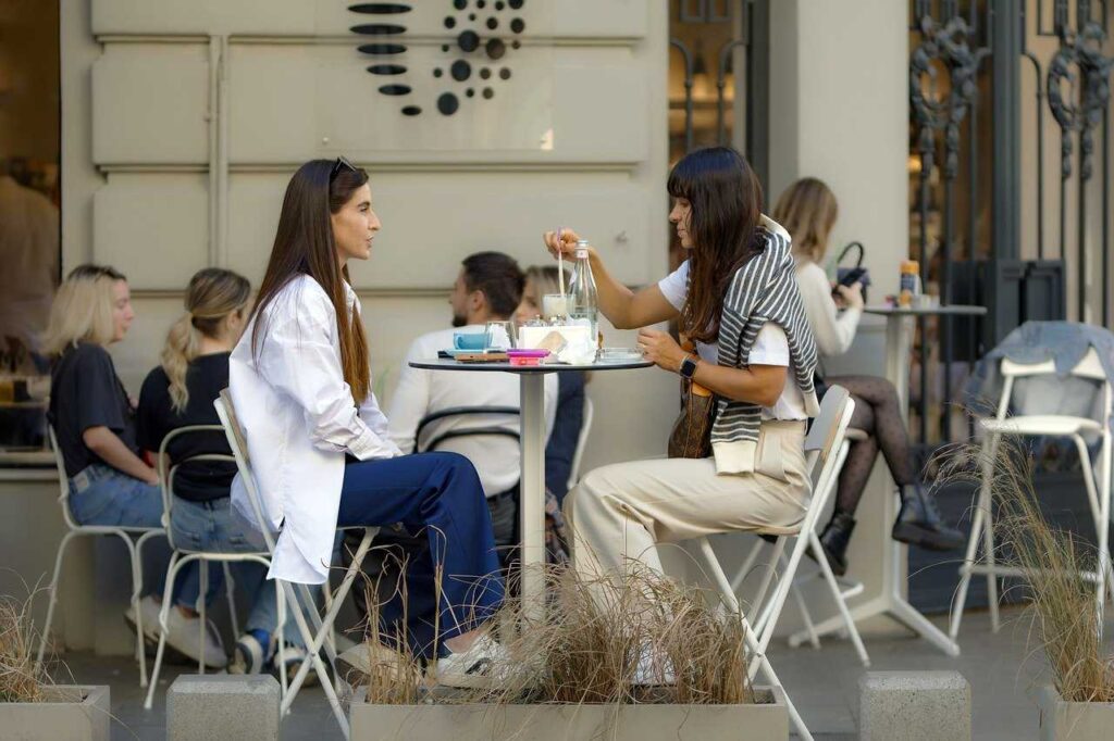 Duas mulheres conversando em um café, ilustrando notícia sobre o que fazer com o sol em gêmeos