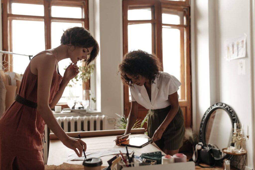 Jovens com roupas elegantes de verão trabalham como estilistas, ilustrando artigo sobre qualidade de vida no trabalho e as revelações da astrologia