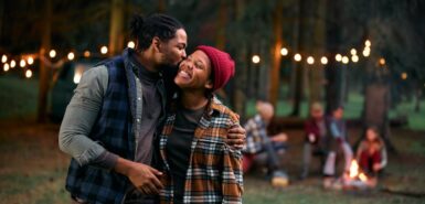 Casal afetuoso curtindo acampar na floresta, ilustrando notícia de que vênus está em câncer e o impacto desse trânsito