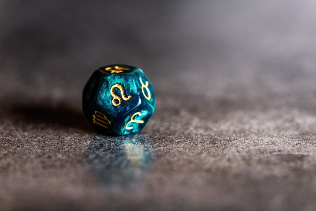 Um dado com múltiplos lados, com o símbolo do signo de Leão em destaque
