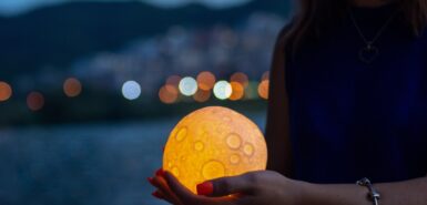 um objeto representando a lua em mãos femininas