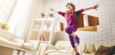 uma criança brinca com asas de foguete dentro de casa