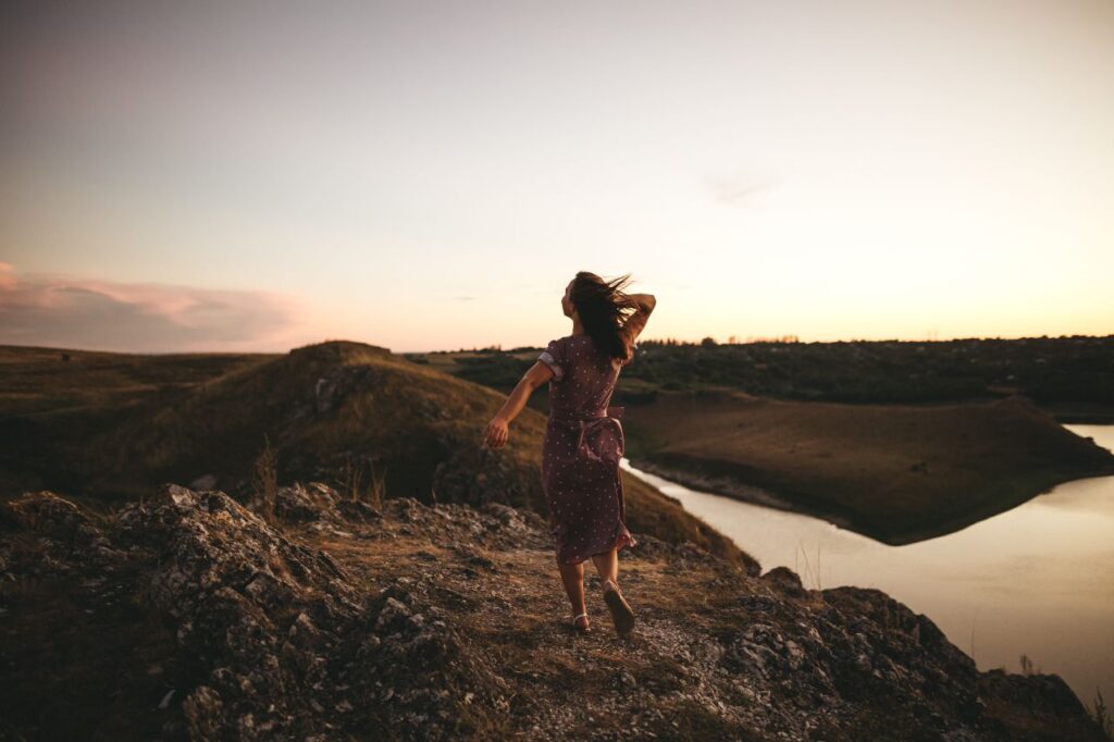uma mulher com um vestido olha para o horizonte de forma descontraída