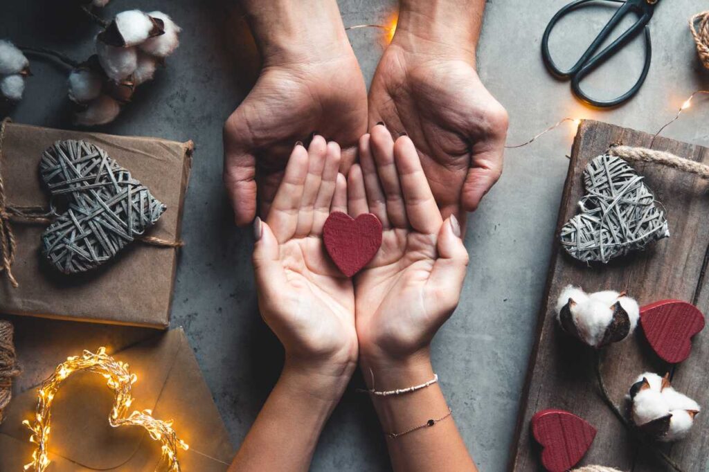 Mãos masculinas seguram as mãos femininas. Coração nas mãos. Romance