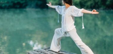 Mulher vestida de branco em uma prática em frente a um lago