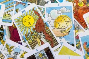 cartas do tarot Rider-Waite-Smith, com destaque para o arcano do Sol e para a carta de ouro