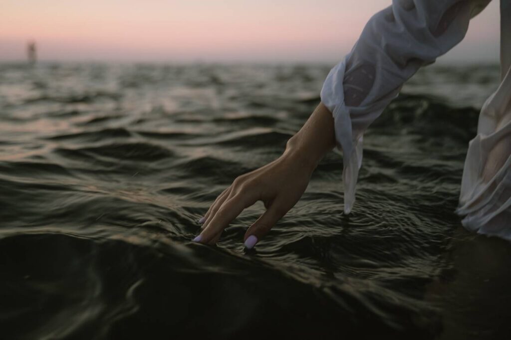 mulher movendo a mão pela água
