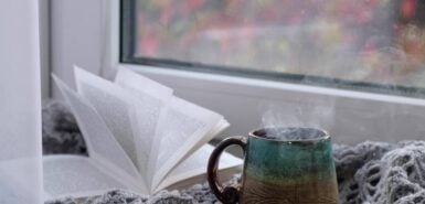 Xícara de café fumegante em um fundo de janela de dia chuvoso. ambiente aconchegante