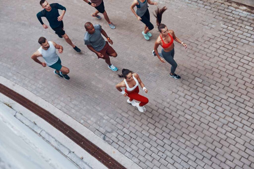 Vista superior de jovens em roupas esportivas correndo enquanto se exercitam ao ar livre