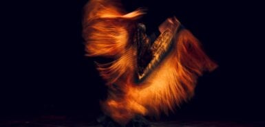 Dançarina de flamenco em traje tradicional com xale motion blur. Dança espanhola flamenca no palco