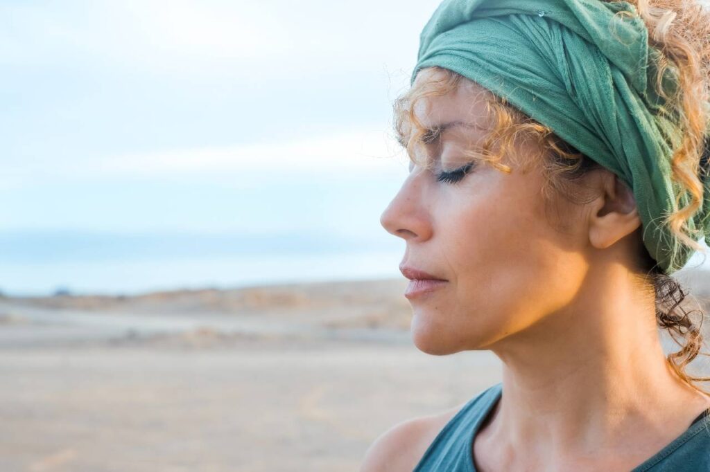 Uma ao ar livre com olhos fechados e expressão serena