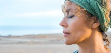 Uma ao ar livre com olhos fechados e expressão serena