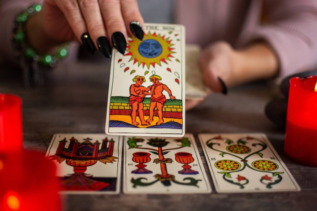 Mãos femininas mostando cartas durante tiragem de tarot
