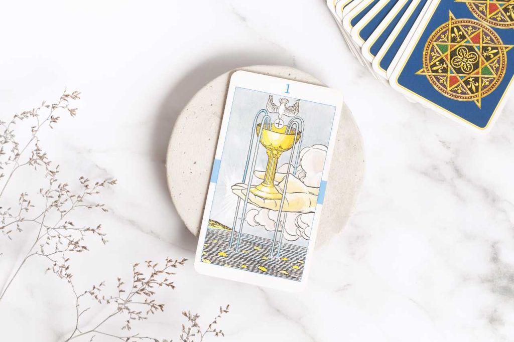 carta do ás de copas no tarot universal, em um mármore branco