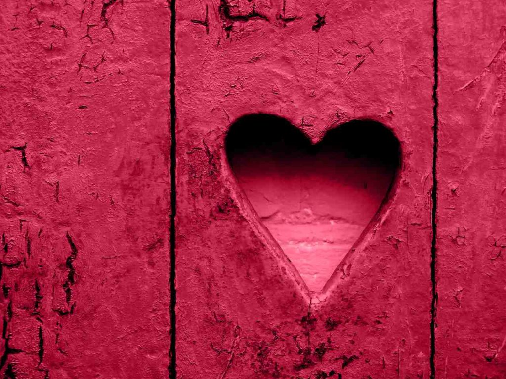 forma de coração na parede rústica de madeira. Signo do coração, buraco. Cor Viva Magenta. Coração de cor Viva Magenta p
