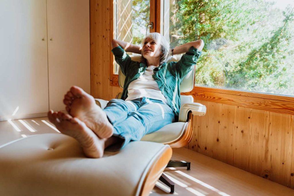 Mulher relaxando na poltrona apreciando a vista da natureza