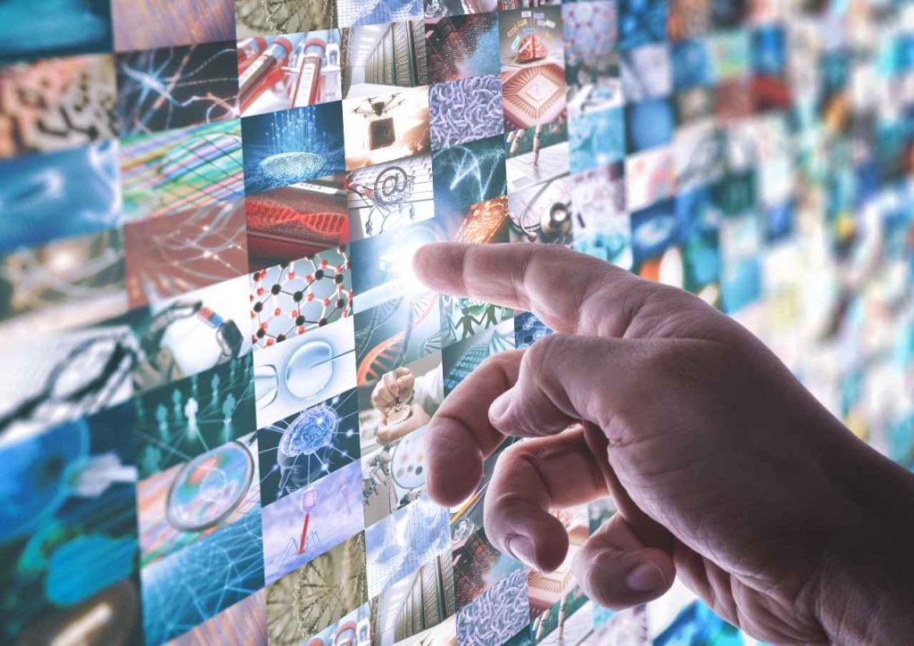 A mão toca o painel de led com tela sensível ao toque com várias imagens sobre tecnologia e ciência