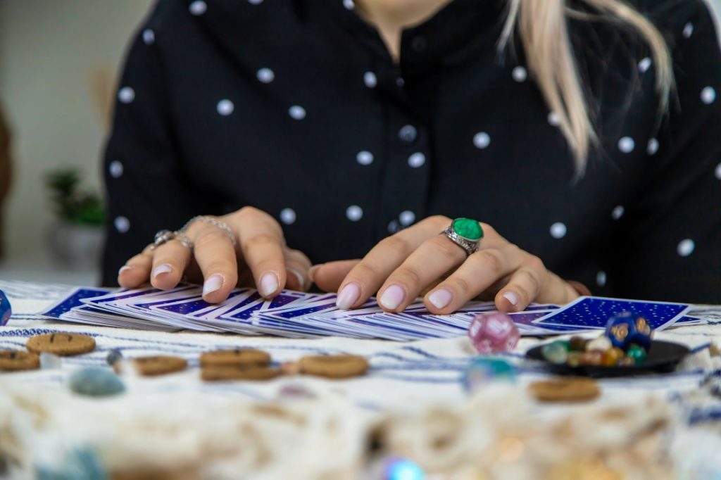 Uma cartomante lê com cartas de tarot. Foco seletivo